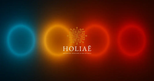 Dégradé horizontal illustrant les 4 longueurs d’onde LED — bleu, jaune, rouge et infrarouge — dans une ambiance tech-luxe inspirée de l’univers Holiaē