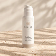 Exfoliant Anti-Taches à l’Acide Kojique HOLIAĒ avec tube et étui sur fond ivoire