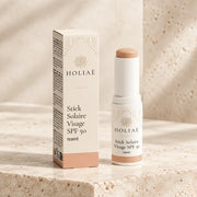 Stick Solaire Visage SPF50 Teinté HOLIAĒ avec étui sur fond ivoire