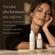 Femme avec les soins du Coffret Anti-Taches Essentiels HOLIAĒ pour taches brunes, teint uniforme et éclat