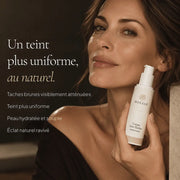 Femme avec la Crème Anti-Taches à l’Acide Kojique HOLIAĒ pour taches brunes, uniformité du teint et hydratation