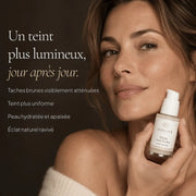 Femme avec le Sérum Anti-Taches à l’Alpha-Arbutine HOLIAĒ pour taches brunes, uniformité du teint et éclat