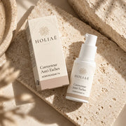 Correcteur Anti-Taches à l’Acide Kojique 1 % HOLIAĒ en mise en scène éditoriale sur travertin