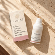 Crème Contour des Yeux Raffermissante aux Peptides HOLIAĒ en mise en scène éditoriale sur travertin