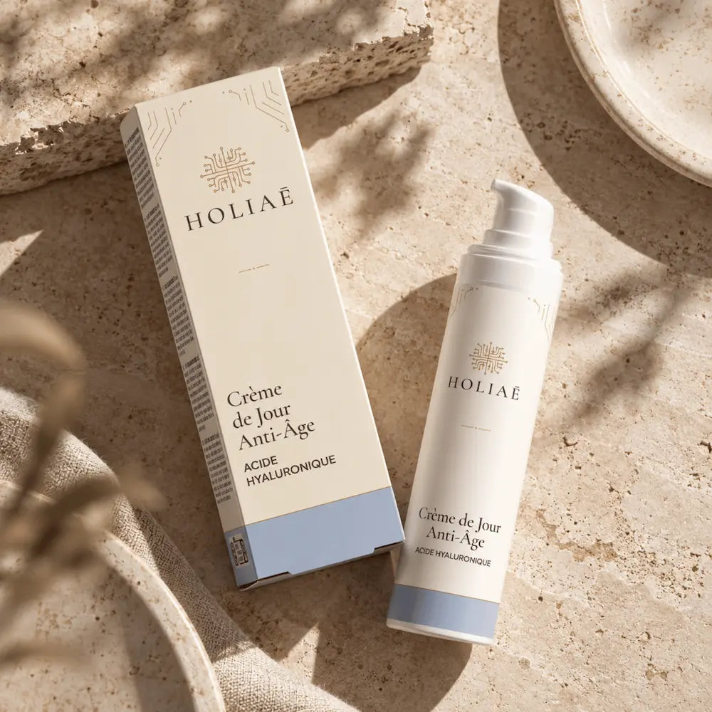 Crème de Jour Anti-Âge à l’Acide Hyaluronique HOLIAĒ en mise en scène éditoriale sur travertin
