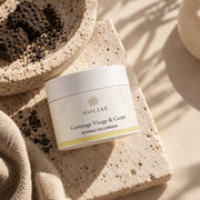 Gommage Visage & Corps au Sable Volcanique HOLIAĒ en mise en scène éditoriale sur travertin