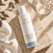 Lotion Tonique Hydratante à l’Eau de Rose HOLIAĒ en mise en scène éditoriale sur travertin