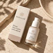 Sérum Anti-Taches à l’Alpha-Arbutine HOLIAĒ en mise en scène éditoriale sur travertin