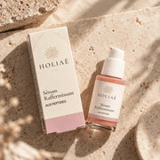 Sérum Raffermissant aux Peptides HOLIAĒ en mise en scène éditoriale sur travertin