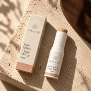 Stick Solaire Visage SPF50 Teinté HOLIAĒ en mise en scène éditoriale sur travertin