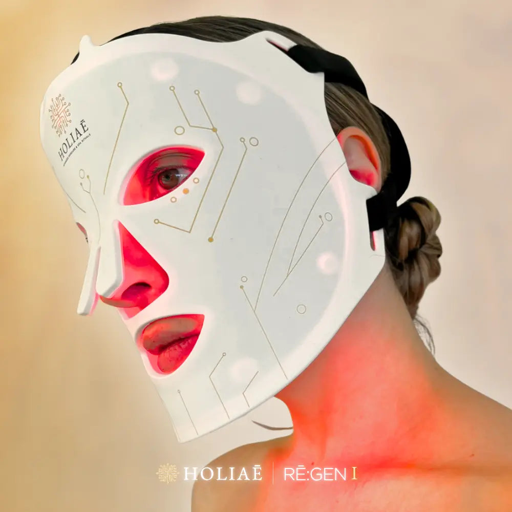 Femme portant le masque LED Holiaē RĒ:GEN I en lumière rouge, rituel régénérant inspiré des soins spa 5 étoiles.