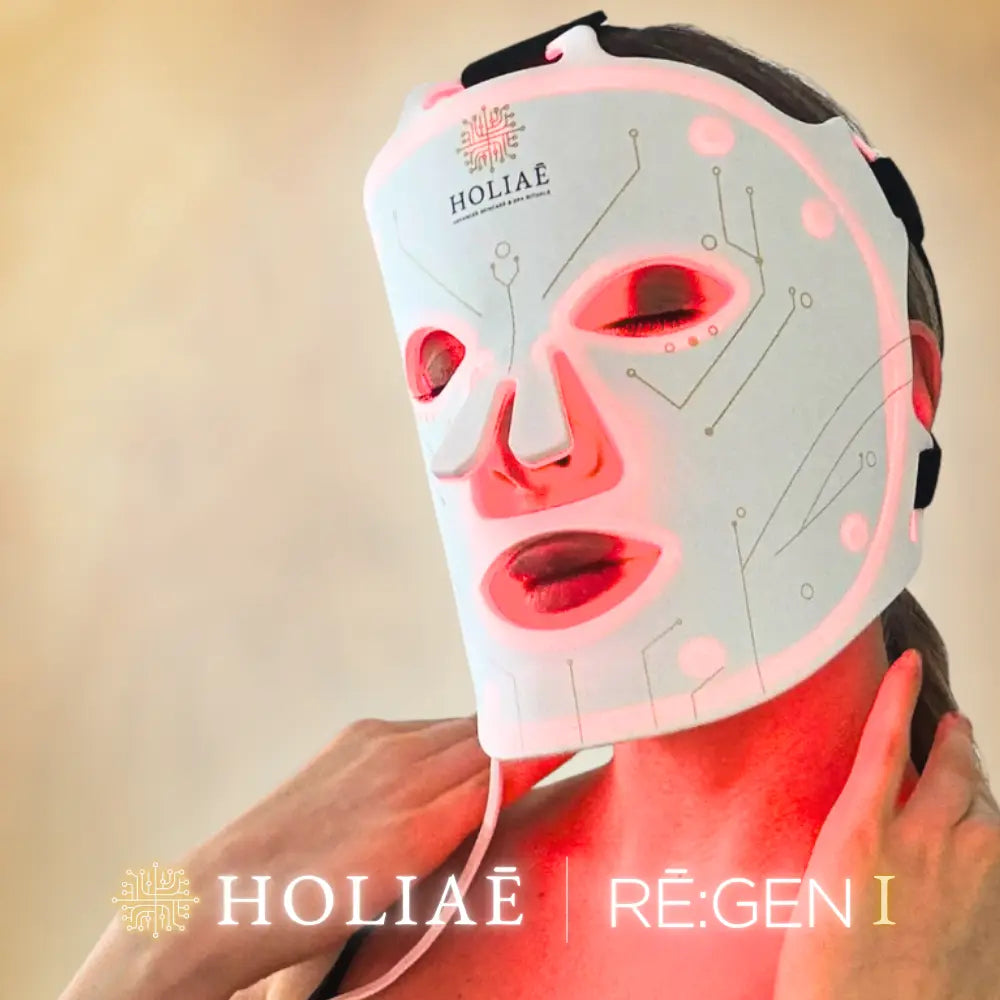 Femme utilisant le masque LED Holiaē RĒ:GEN I en lumière rouge 660 nm, soin anti-âge professionnel pour stimuler le collagène et régénérer la peau.